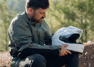 A rider wearing the Shoei GT-Air 3 helmet while riding a sport-touring motorcycle on a winding road.