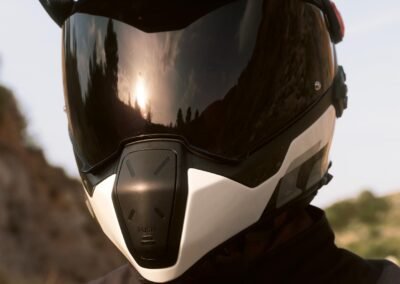 The BMW GS Rallye Carbon helmet in a matte finish, displayed on a stand with its sun peak and visor visible.