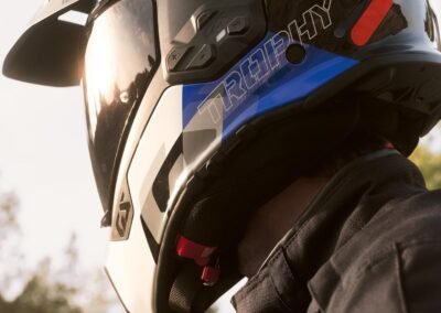 The BMW GS Rallye Carbon helmet in a matte finish, displayed on a stand with its sun peak and visor visible.