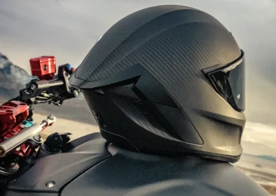 Ruroc EOX motorcycle helmet in a matte black finish, showing its aerodynamic profile and Quad-Matrix carbon fiber shell.