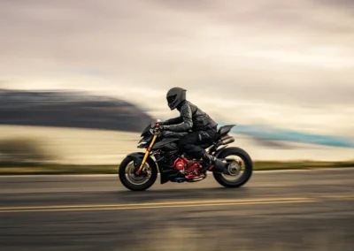 Ruroc EOX motorcycle helmet in a matte black finish, showing its aerodynamic profile and Quad-Matrix carbon fiber shell.