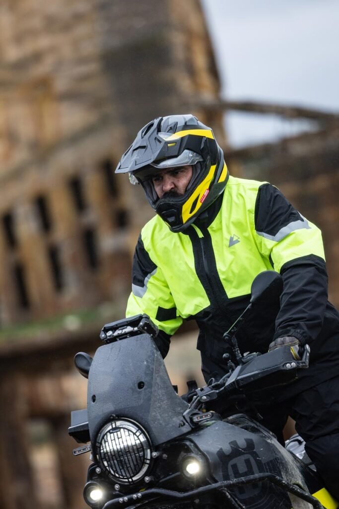 Action shot of a rider on a BMW GS motorcycle wearing the Touratech Storm Rain Suit in heavy rain.