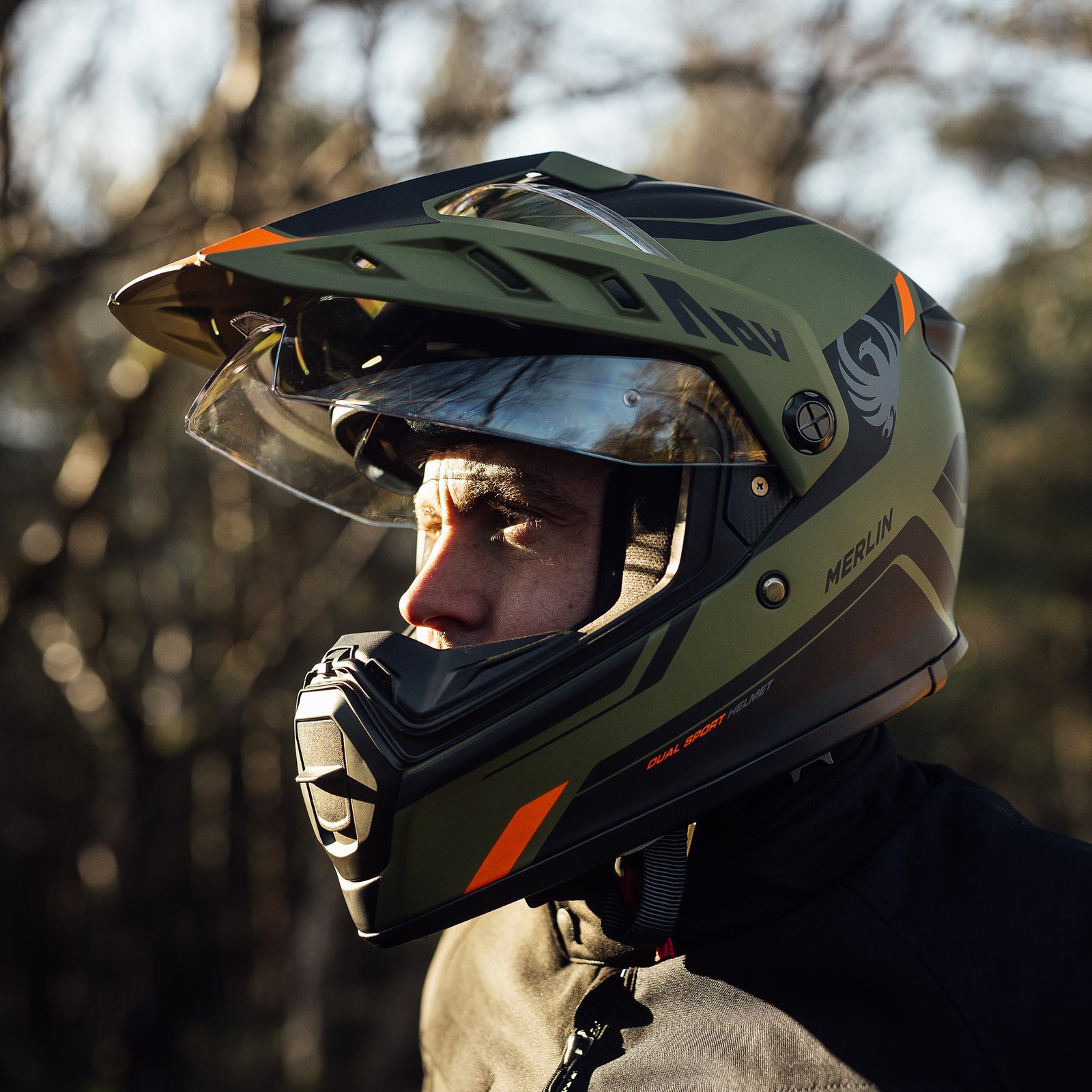 A rider wearing the Merlin Torres helmet on an adventure motorcycle, demonstrating the helmet's scale and on-bike profile.