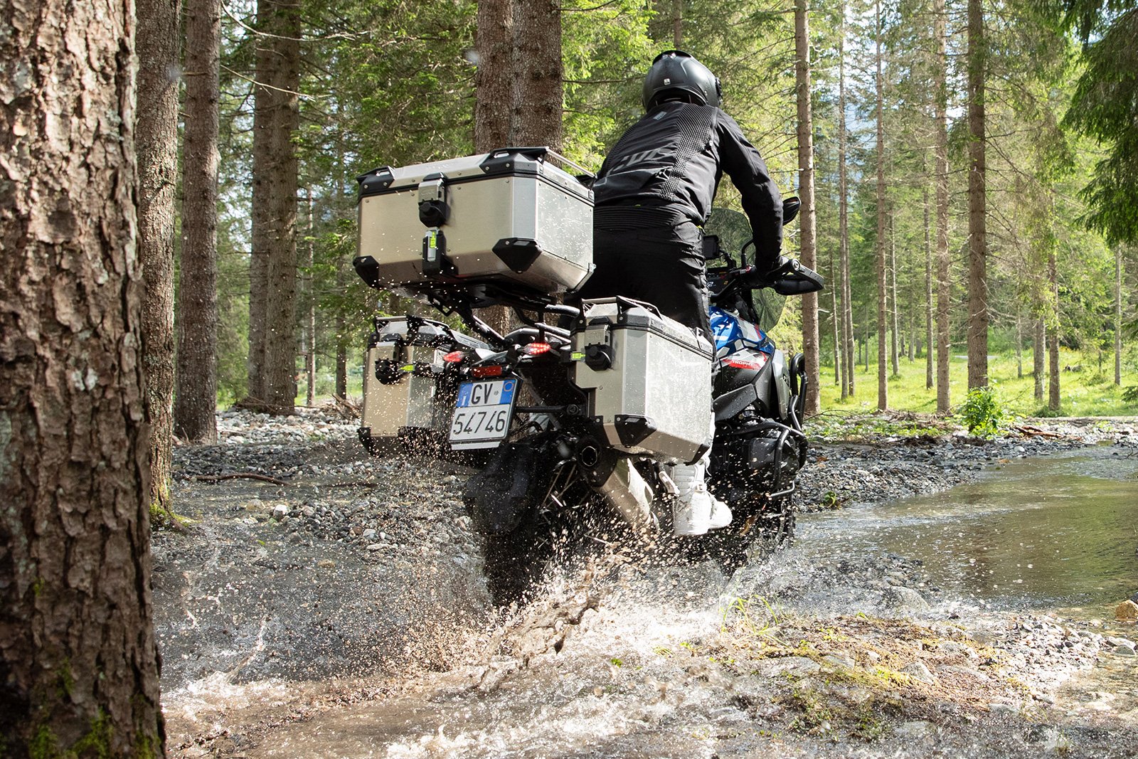 A pair of silver GIVI Trekker Outback EVO panniers mounted securely to the side of an adventure motorcycle.
